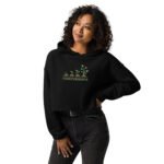 Strength in Growth Crop Hoodie in black featuring inspiring text and a plant growth graphic, showcasing resilience and empowerment.